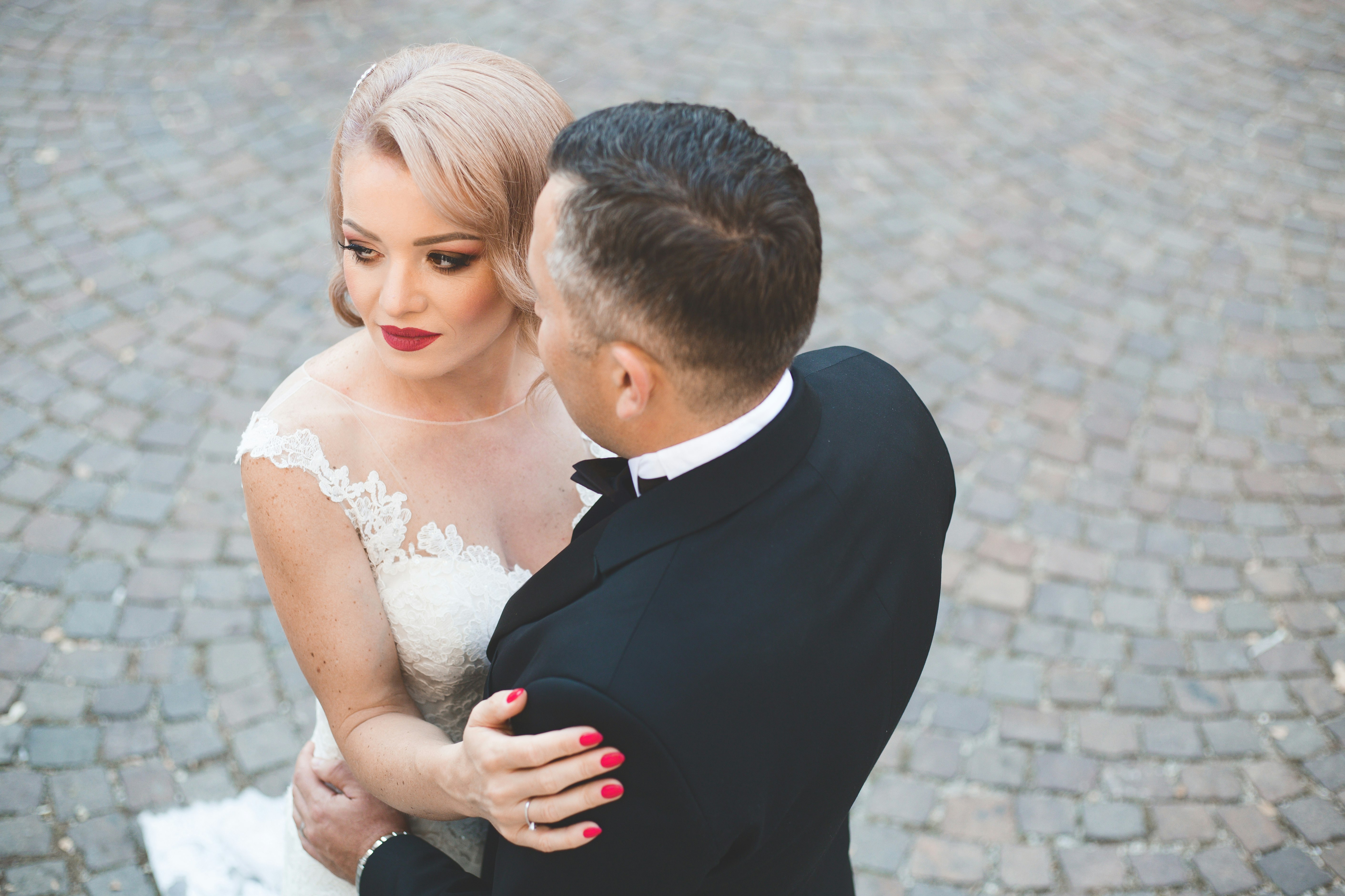 man in black suit kissing woman in white wedding dress