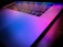 Close-up of a satisfied young woman using a sleek luminova keyboard in a bright, modern workspace.