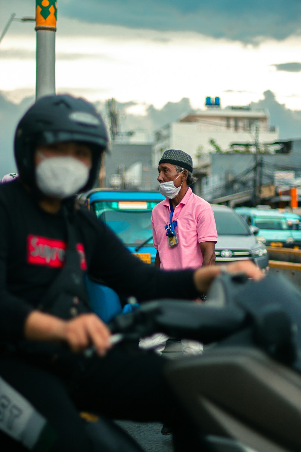 man in pink polo shirt and black pants sitting on black motorcycle during daytime