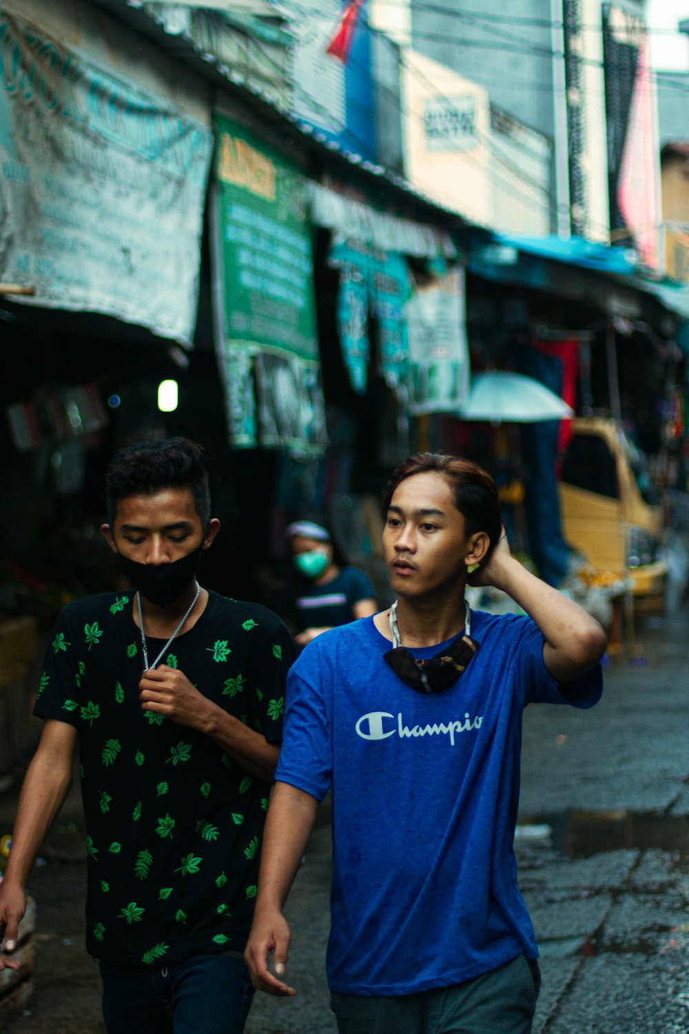 boy in blue crew neck t-shirt standing beside wall during daytime