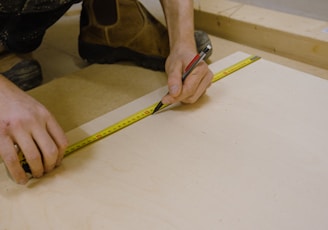 person holding yellow and black tape measure