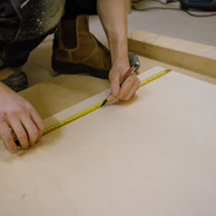 A construction worker measuring wood for a custom project.