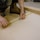 Close-up of hands measuring and marking wood on a construction site.