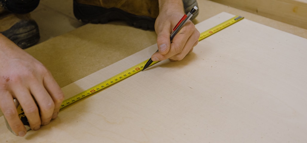 person holding yellow and black tape measure