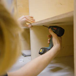 person holding black and red cordless hand drill