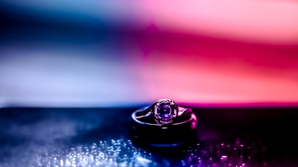 Close-up of a custom emerald and amethyst ring sparkling under soft light.