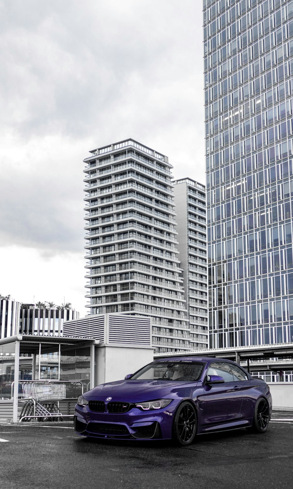 purple car parked beside white building during daytime