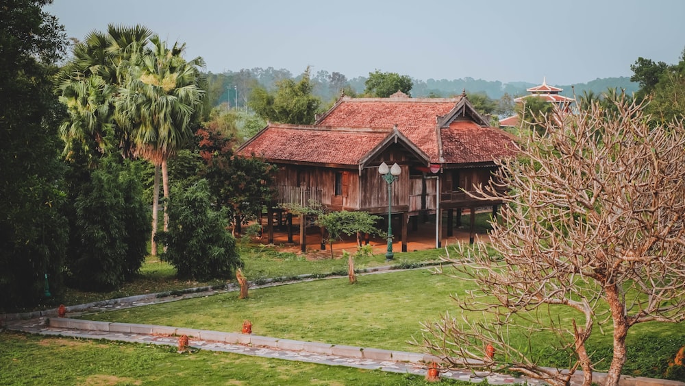 brown wooden house surrounded by green trees during daytime