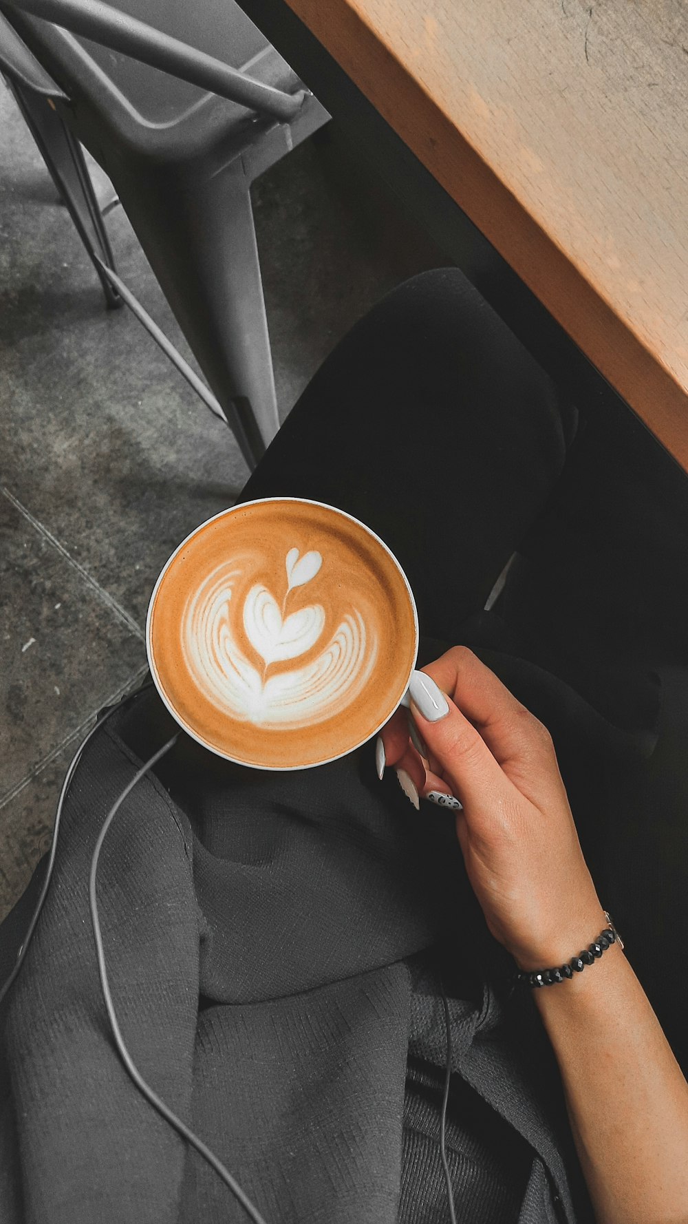 person holding white ceramic mug with brown liquid