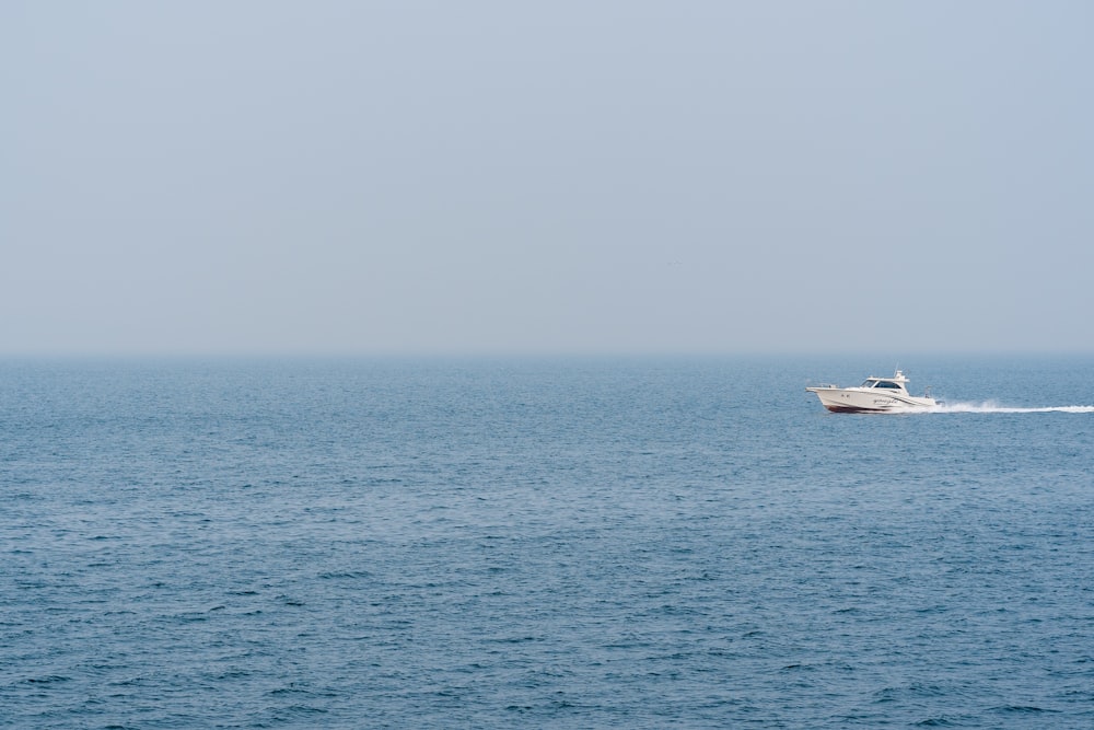 white boat on sea during daytime
