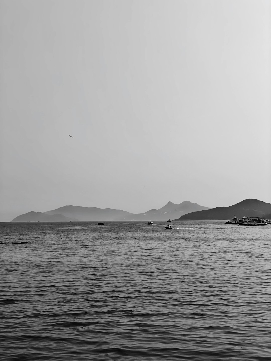 grayscale photo of body of water near mountain