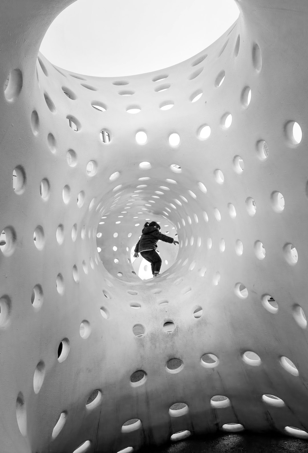 person in black jacket walking on white and black polka dot floor