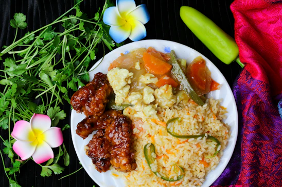 A vibrant plate of Asian fusion cuisine with colorful vegetables and golden ginger accents.