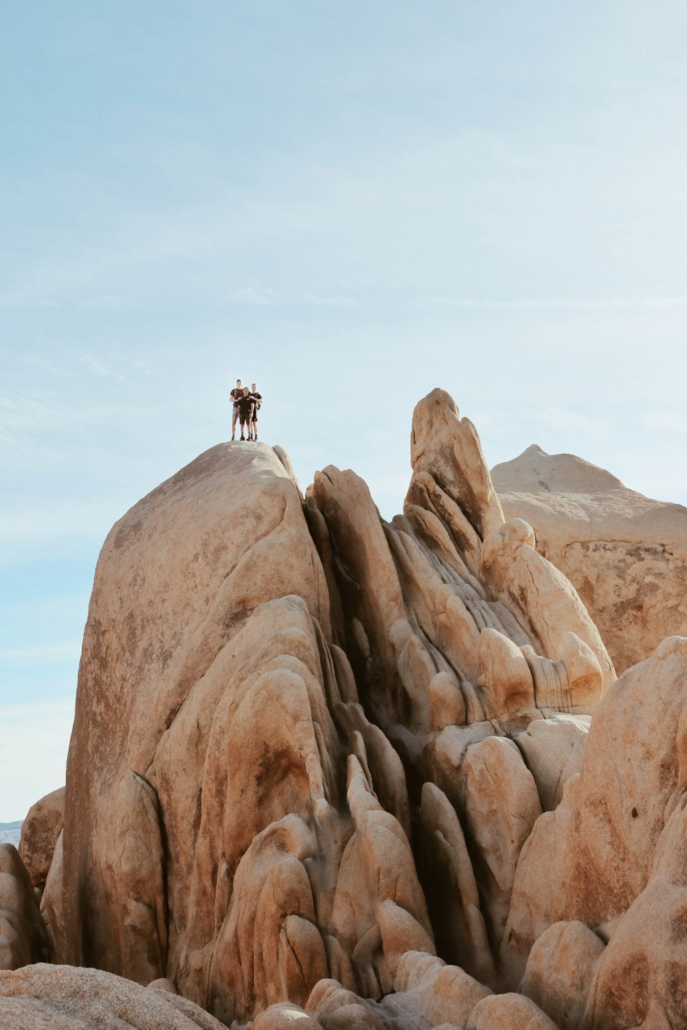 pessoa em pé na formação rochosa marrom durante o dia