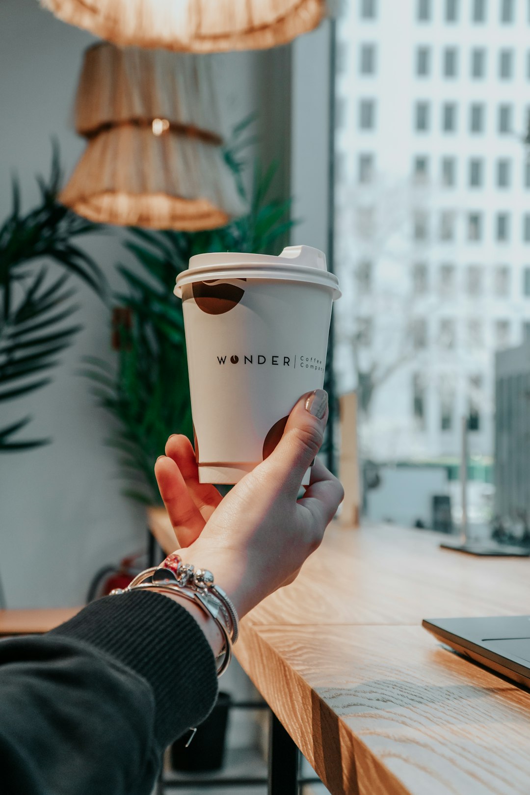 person holding white disposable cup