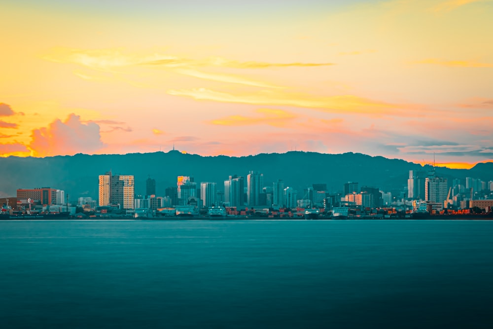 city skyline across body of water during sunset