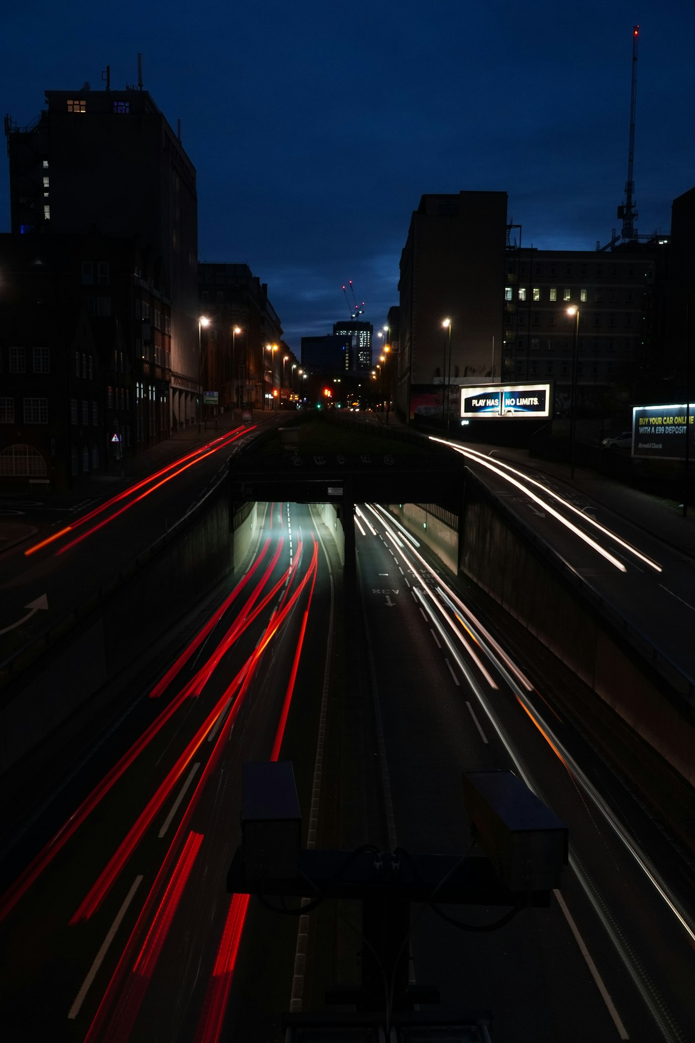 Car light trails streaking along a night road