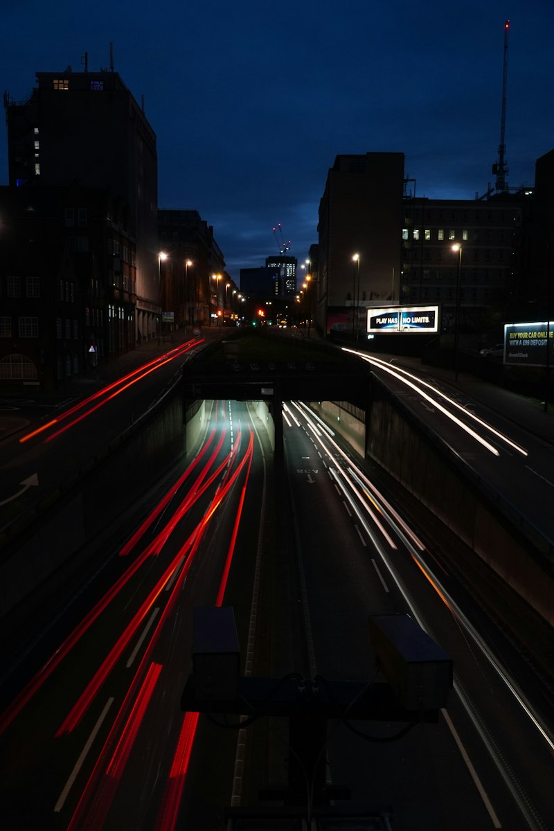 Car light trails streaking along a night road