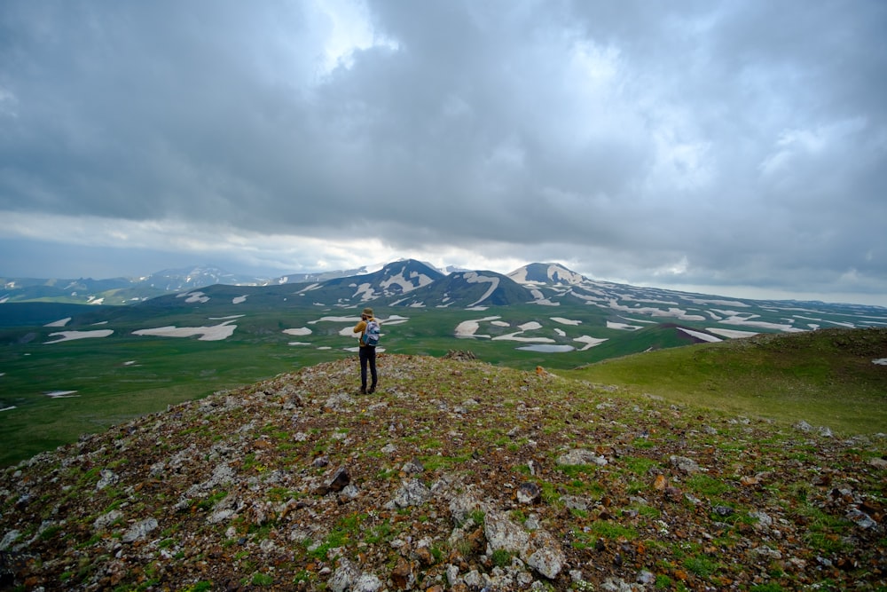 person in black jacket standing on green grass field during daytime