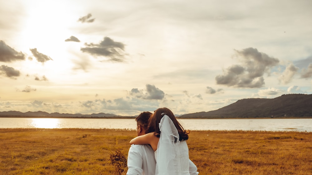 couple kissing on green grass field during daytime