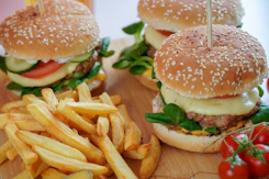 burger with lettuce and fries on brown wooden table