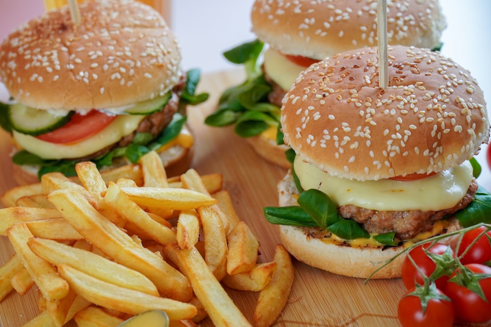 hambúrguer com alface e batatas fritas sobre mesa de madeira marrom