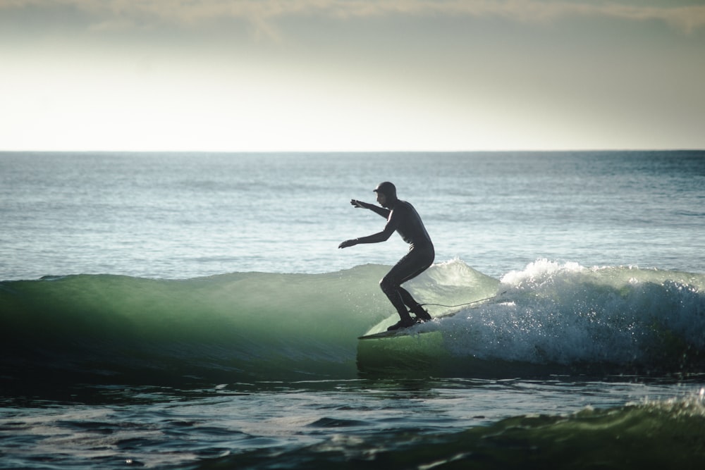 man surfing on sea waves during daytime