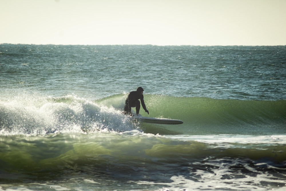 man surfing on sea waves during daytime