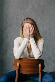 woman in white long sleeve shirt covering her face