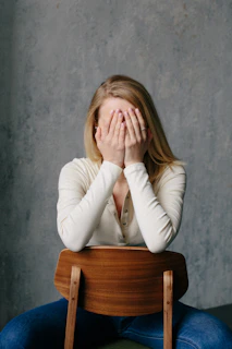 woman in white long sleeve shirt covering her face