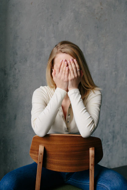 woman in white long sleeve shirt covering her face