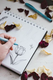 person holding purple and white coloring book