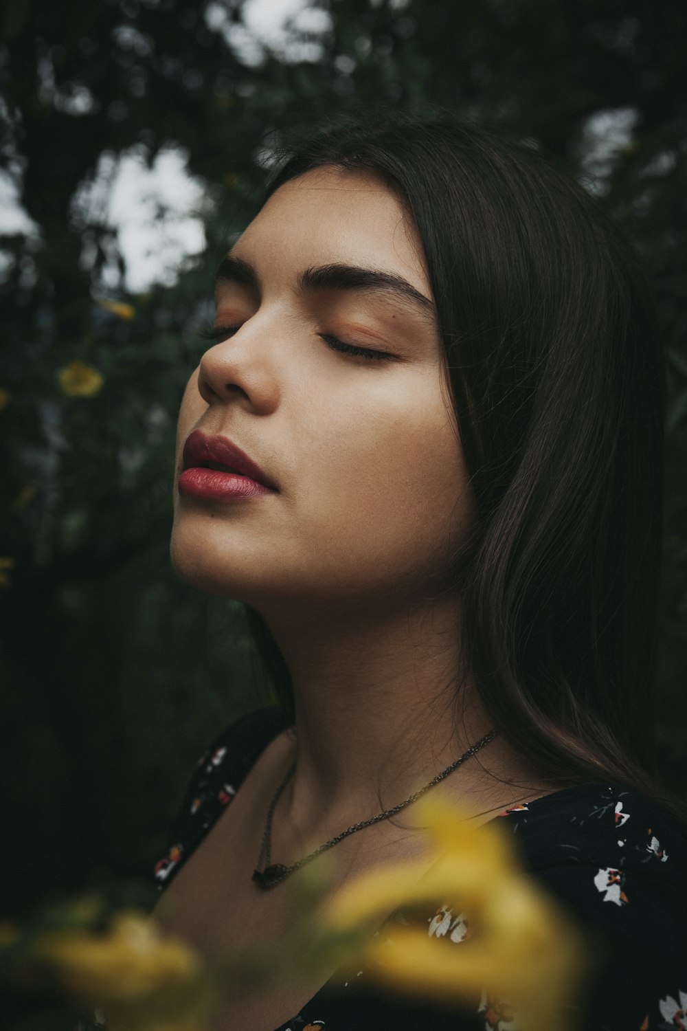 Mujer con camisa floral negra y amarilla