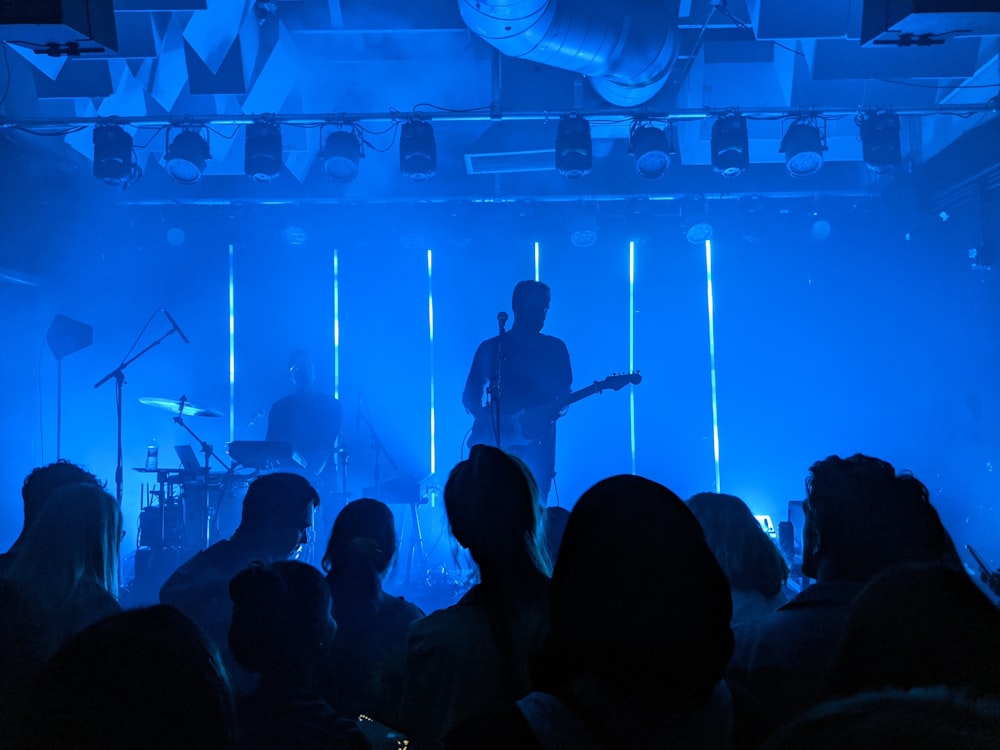 man in black shirt playing guitar on stage