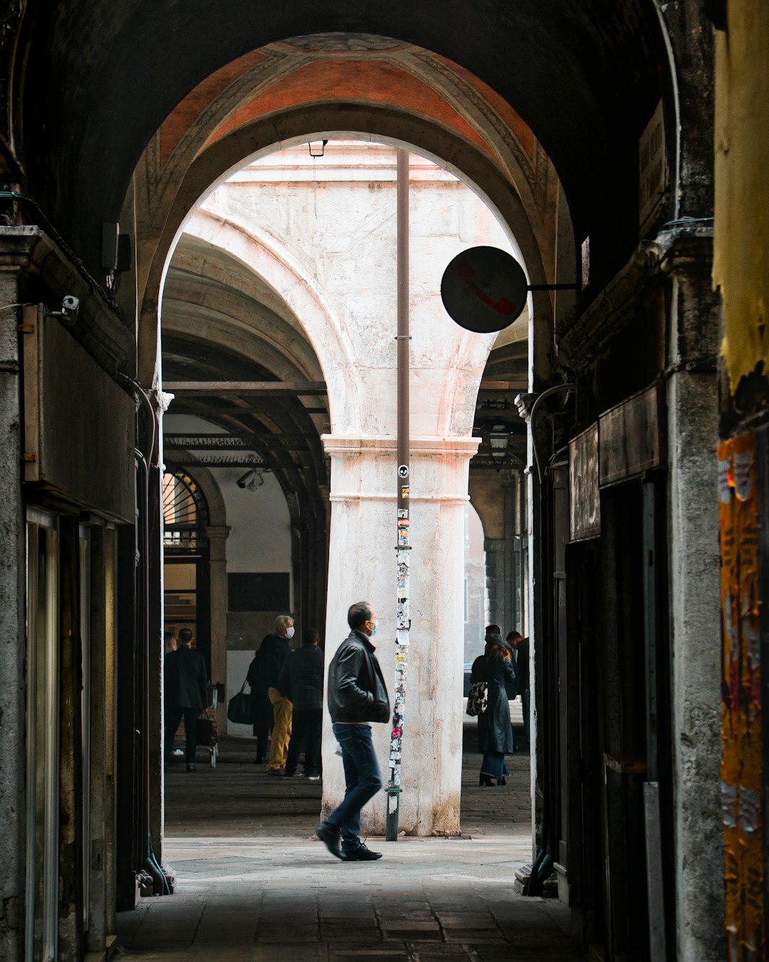 man in black jacket standing on sidewalk during daytime