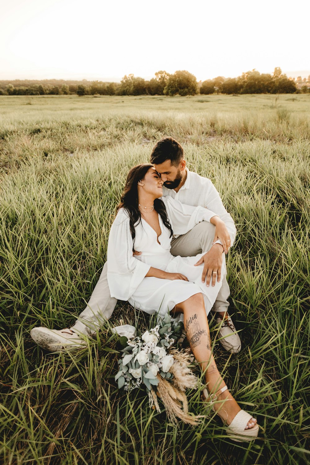 hombre y mujer besándose en el campo de hierba durante el día
