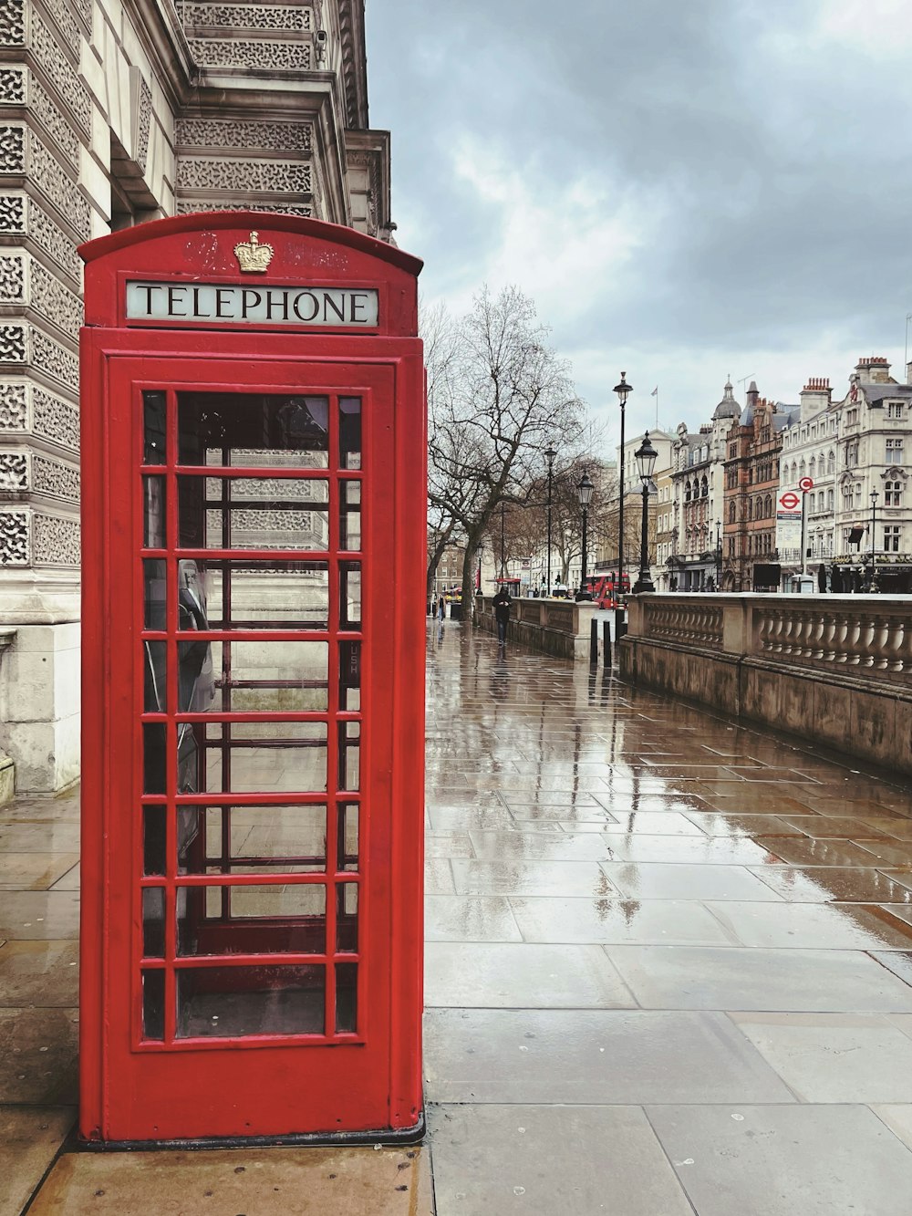 Cabina telefonica rossa vicino all'edificio marrone durante il giorno