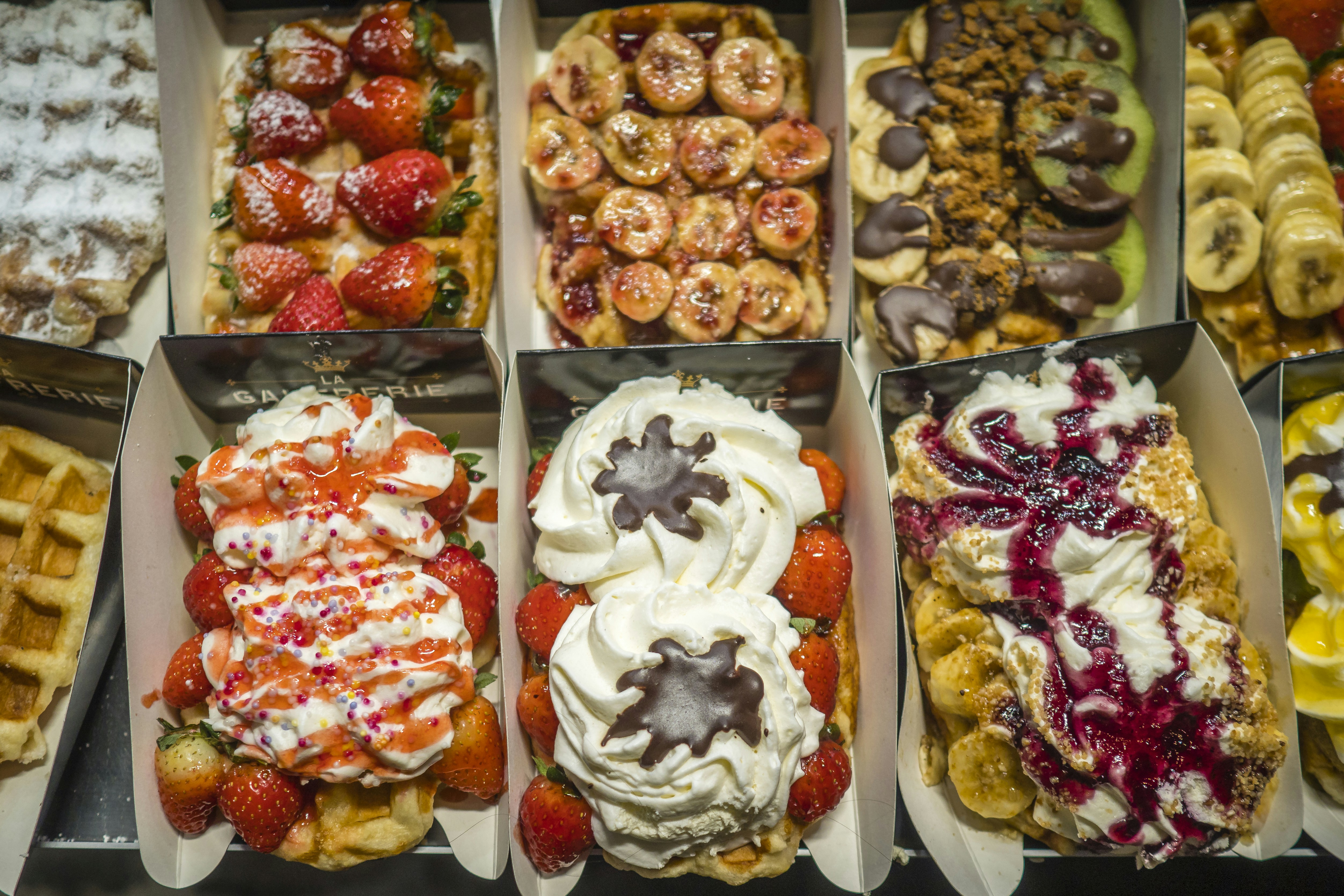 assorted flavor of food on white tray, Waffles with cream, chocolate, fruit and jam -  Belgium
