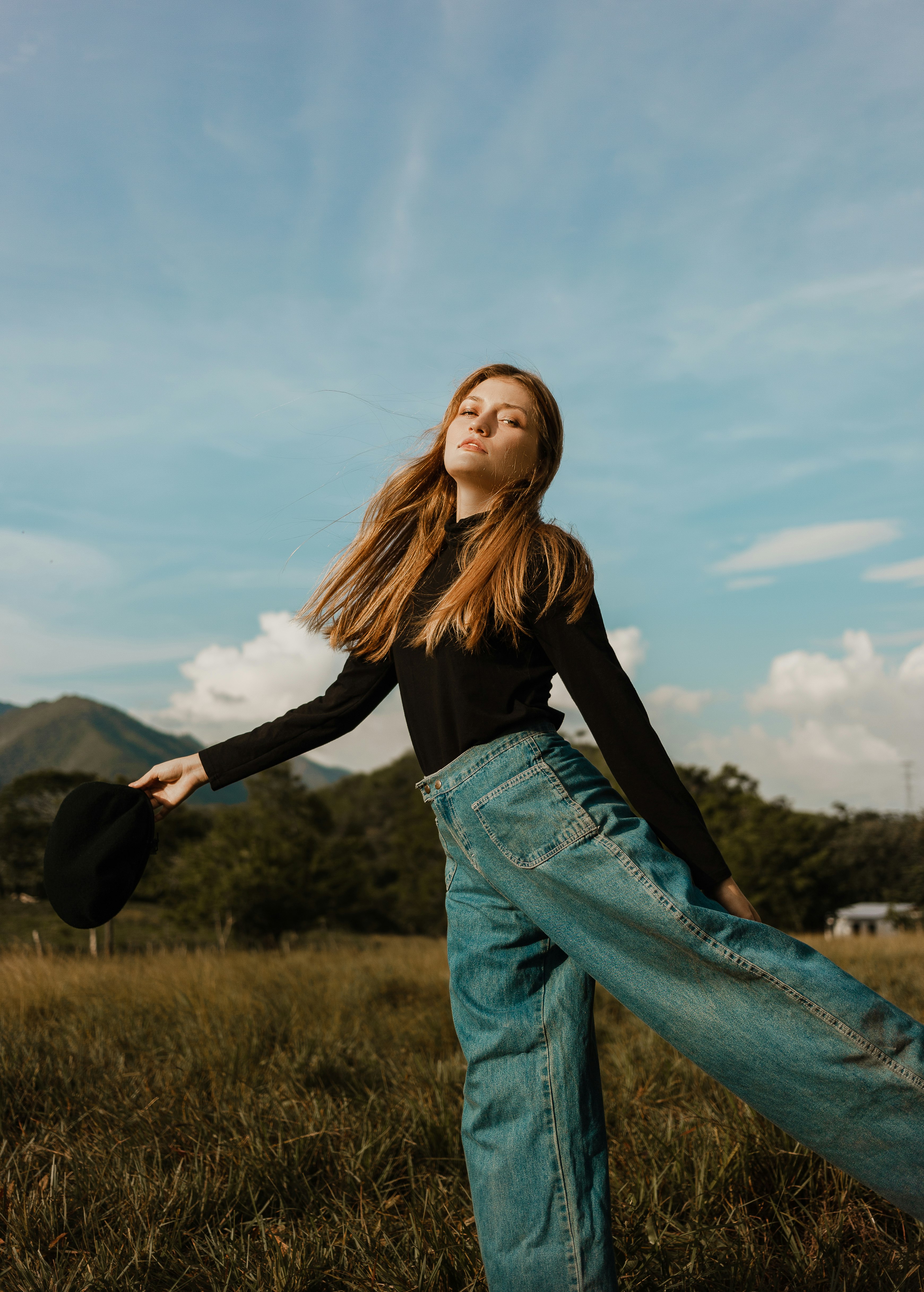 woman in black long sleeve shirt and blue denim jeans standing on green grass field during