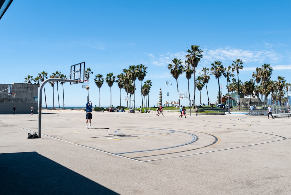 people playing basketball on basketball court during daytime