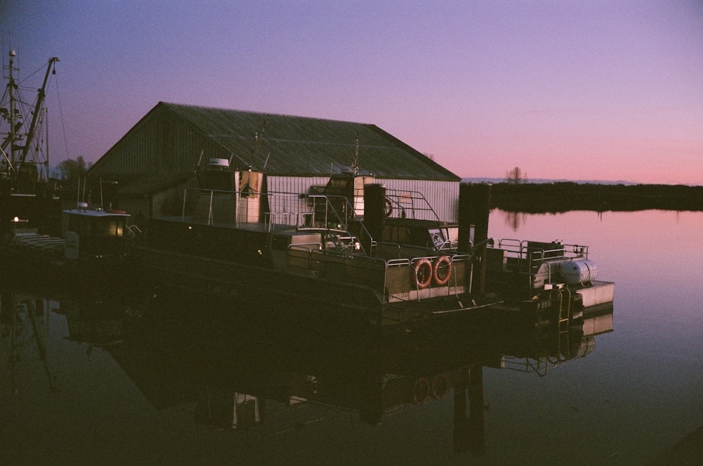 silhouette of a boat on a body of water during sunset