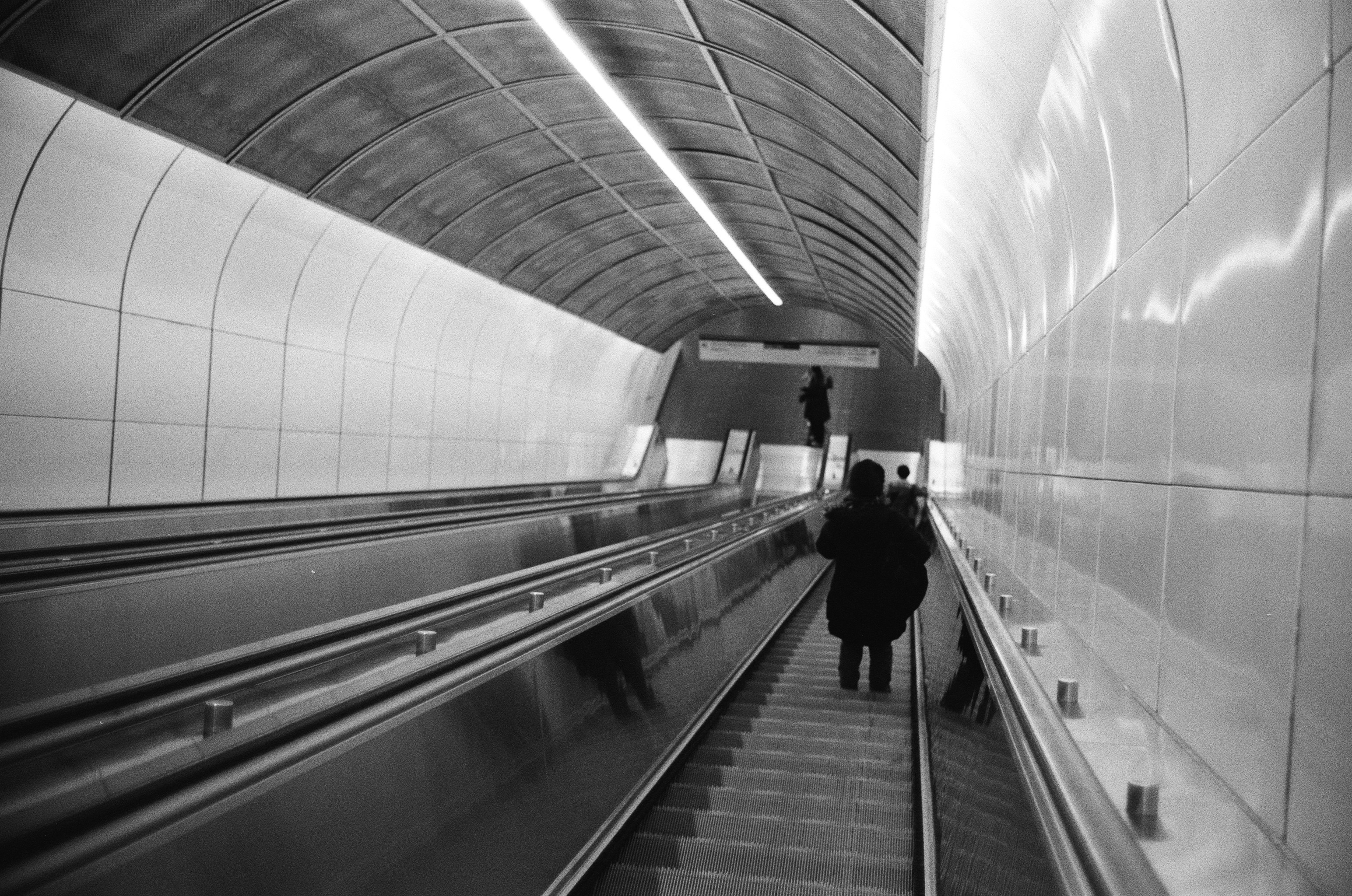 man in black jacket standing on train station