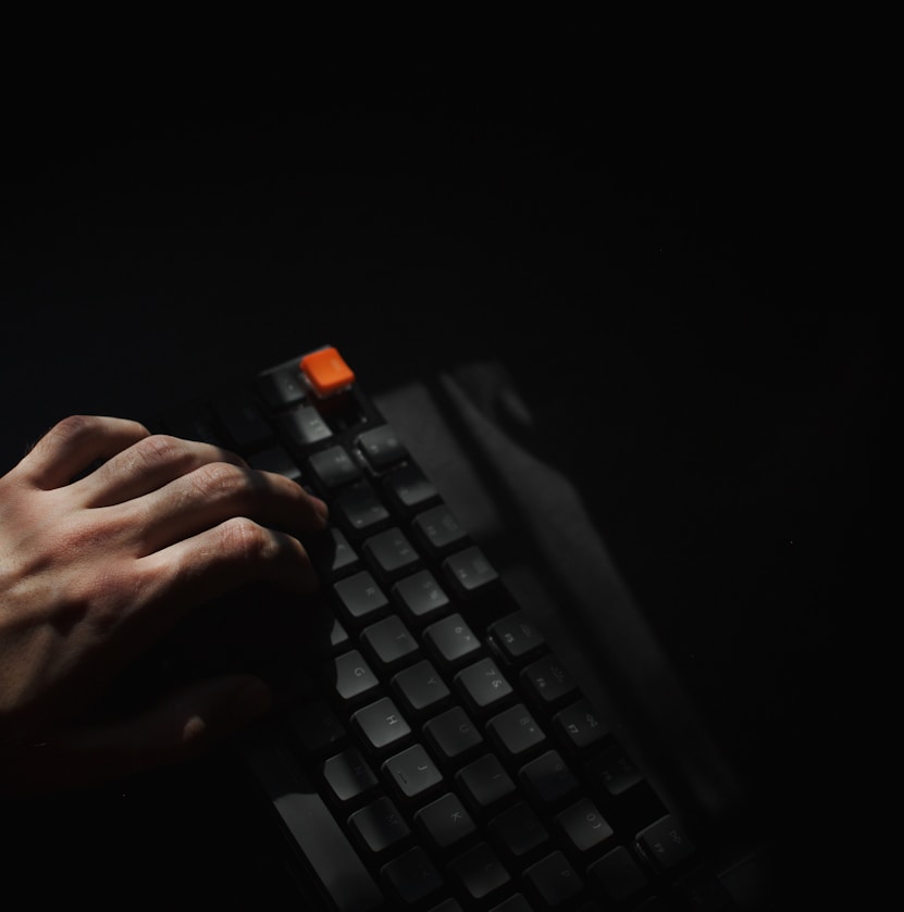 person holding black computer keyboard