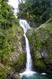 waterfalls in the middle of green grass covered mountain