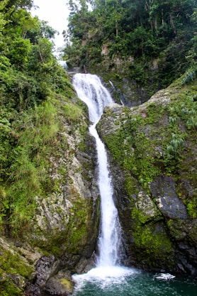 waterfalls in the middle of green grass covered mountain