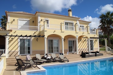 white and black motorcycle parked beside white concrete building during daytime