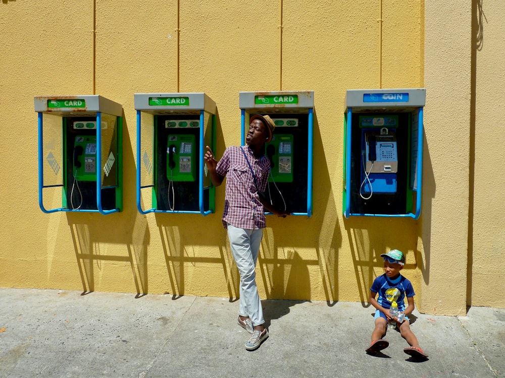 woman in pink and white stripe shirt and beige pants standing beside atm machine