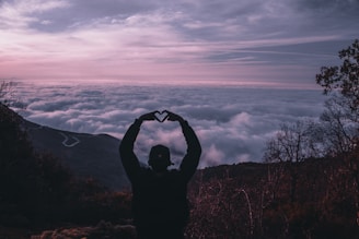 silhouette of man holding camera during sunset