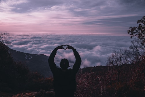 silhouette of man holding camera during sunset