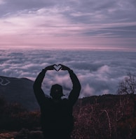 silhouette of man holding camera during sunset